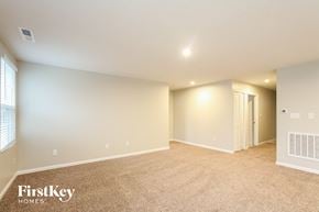 Greenwood house for rent - A spacious room with a carpeted floor and a window on the left side.