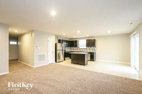 Greenwood house for rent - A spacious living room with a kitchenette in the background.