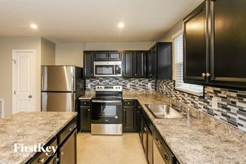 Greenwood house for rent - A kitchen with black cabinets and a stainless steel refrigerator.