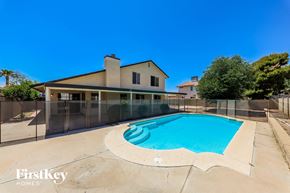 Peoria house for rent - a pool with a fence around it and a house in the background