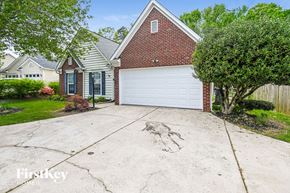 Charlotte house for rent - a large driveway in front of a brick house with a white garage door