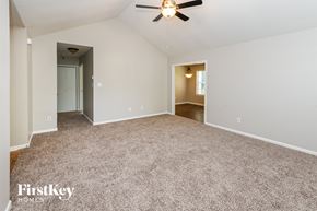 Charlotte house for rent - a spacious living room with carpet and a ceiling fan
