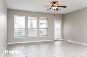 Red Oak house for rent - A spacious room with a ceiling fan and three windows.