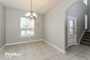 Red Oak house for rent - A room with a chandelier, a window with blinds, and a staircase.