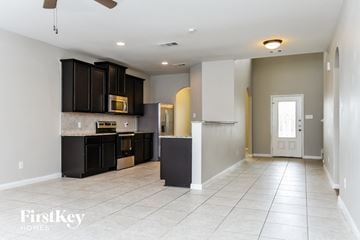 Red Oak house for rent - A spacious kitchen with dark brown cabinets and a white ceiling fan.