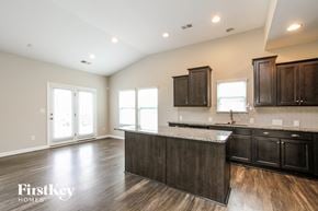 Mooresville house for rent - A kitchen with dark wood cabinets and a white countertop.