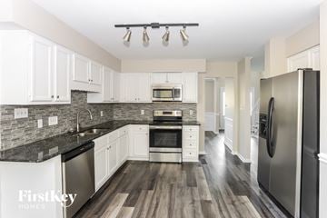 Charlotte house for rent - a kitchen with white cabinets and stainless steel appliances