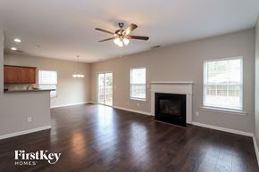 Woodstock house for rent - A spacious living room with wood floors and a fireplace.