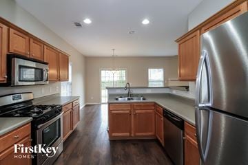 Woodstock house for rent - A kitchen with wooden cabinets and stainless steel appliances.