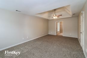 Woodstock house for rent - A spacious room with a ceiling fan and a carpeted floor.