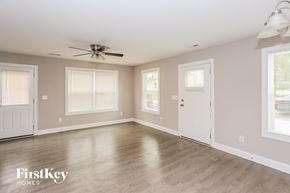 Kannapolis house for rent - A spacious room with a fan on the ceiling and a door on the right side.