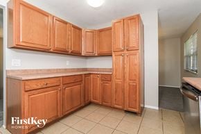 Middletown house for rent - a kitchen with wooden cabinets and tiled floors and a sink