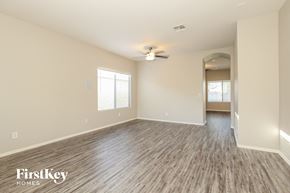 San Tan Valley house for rent - the living room of an empty house with wood flooring and a ceiling fan