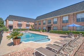 San Antonio apartment for rent - A pool surrounded by lounge chairs and umbrellas.
