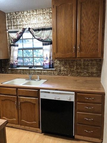 Temple house for rent - A kitchen with wooden cabinets and a black dishwasher.