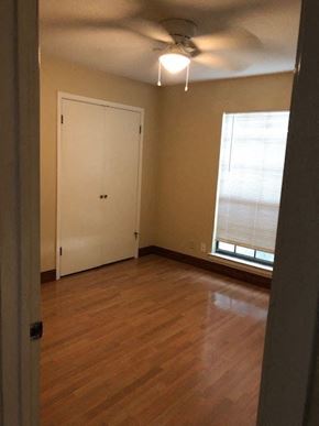 Temple house for rent - A room with a white door and a window with blinds.