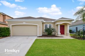 Parrish house for rent - a beige house with a driveway and a lawn
