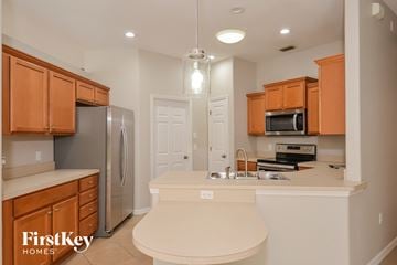 Parrish house for rent - a kitchen with wooden cabinets and a white counter top