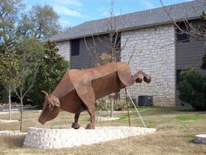Austin apartment for rent - a statue of a cow in front of a house