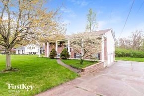 West Chester house for rent - a white and brick house with a lawn and trees