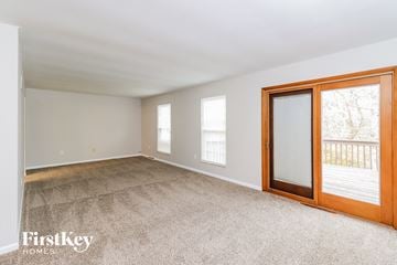 West Chester house for rent - a living room with carpet and sliding glass doors to a balcony