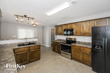 Memphis house for rent - A kitchen with wooden cabinets and a black fridge.
