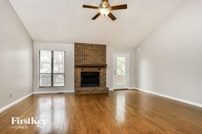 Ballwin house for rent - an empty living room with a brick fireplace and a ceiling fan