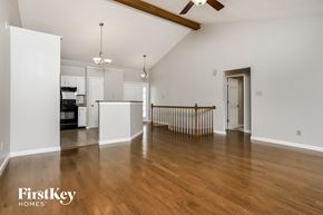 Ballwin house for rent - a living room and kitchen with wood floors and white walls