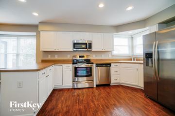 Delaware house for rent - a kitchen with white cabinets and stainless steel appliances