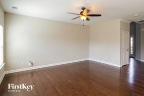 Ladson house for rent - A room with a ceiling fan and wooden floors.