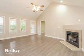 Winston Salem house for rent - A spacious living room with a fireplace and a ceiling fan.
