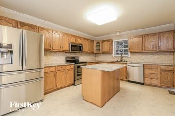 Winston Salem house for rent - A kitchen with wooden cabinets and a stainless steel refrigerator.