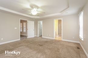 Winston Salem house for rent - A spacious room with a carpeted floor and a ceiling fan.
