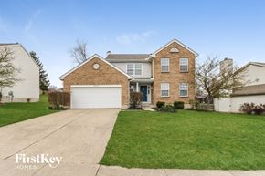 West Chester house for rent - a brick house with a white garage door and a green lawn