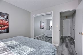 Regina apartment for rent - A bedroom with a bed and a painting on the wall.