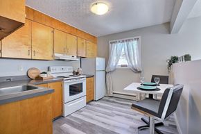 Regina apartment for rent - A kitchen with wooden cabinets and a white refrigerator.