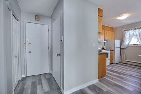 Regina apartment for rent - A kitchen area with a refrigerator, sink, and cabinets.