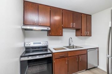 Oakland apartment for rent - A kitchen with brown cabinets and a stainless steel oven.