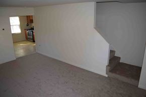 Severn house for rent - a living room with a staircase and a white wall