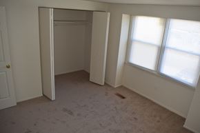 Severn house for rent - an empty bedroom with a closet and two windows