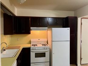 Kentwood apartment for rent - an empty kitchen with white appliances and black cabinets