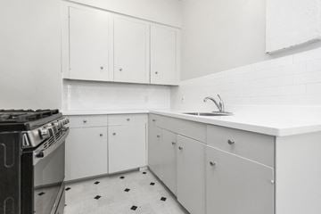 San Francisco apartment for rent - a kitchen with white cabinets and a stove and sink