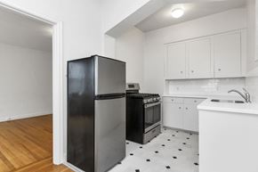 San Francisco apartment for rent - a kitchen with white cabinets and a black refrigerator