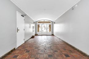San Francisco apartment for rent - a hallway with white walls and a brick floor and white doors