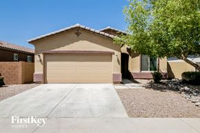 Tolleson house for rent - A house with a garage door and a tree in front.