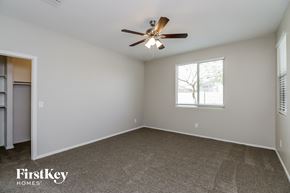 Tolleson house for rent - A spacious room with a ceiling fan and a window with blinds.