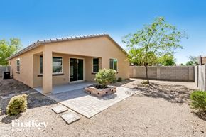 Tolleson house for rent - A house with a tan exterior and a gravel driveway.
