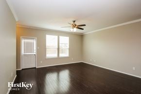 Fort Worth house for rent - a empty living room with wood floors and a ceiling fan