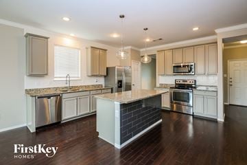 Fort Worth house for rent - a kitchen with white cabinets and a marble counter top