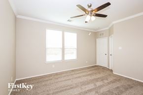 Fort Worth house for rent - a bedroom with carpet and a ceiling fan